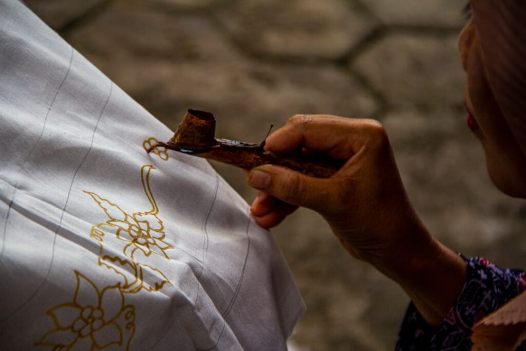 Traditional Indonesian batik making with canting and wax during a batik class in Bali