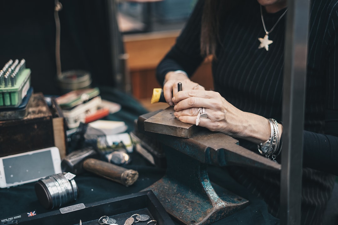 Jewelry maker working by hand at a workshop, illustrating a silver jewelry making class